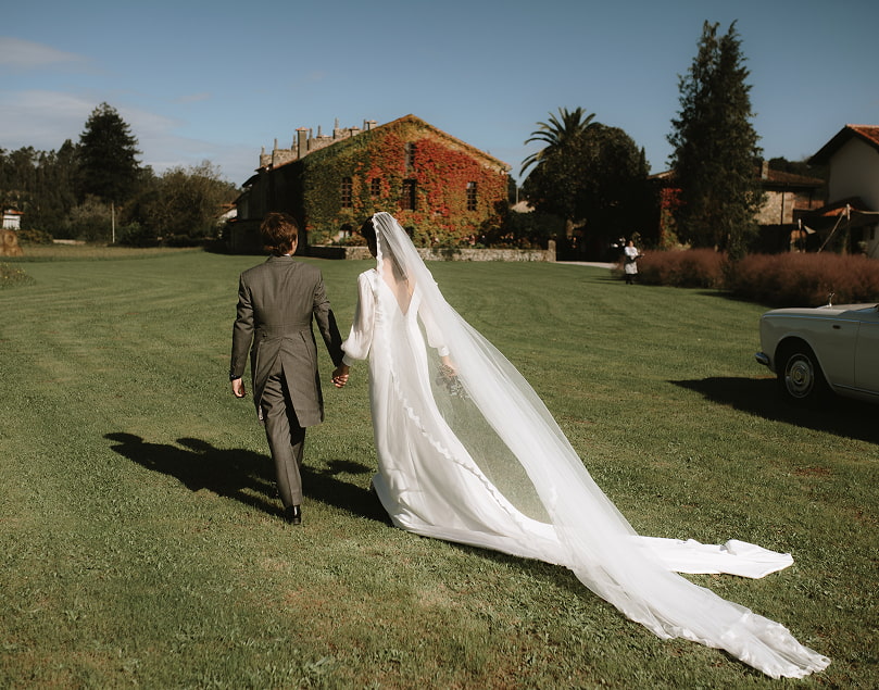Pareja de novios caminando por los jardines de la finca