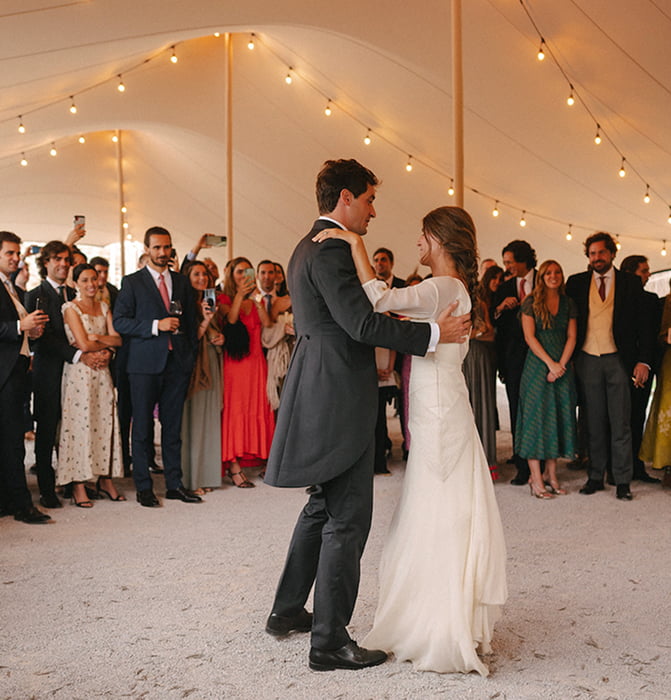 Pareja de novios bailando en el centro de una carpa