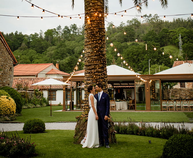 Pareja de novios posando en los jardines de la finca