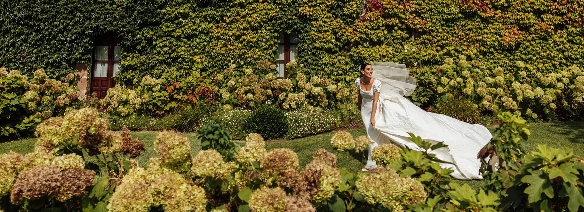 Novia posando entre la verde vegetación del Palacio