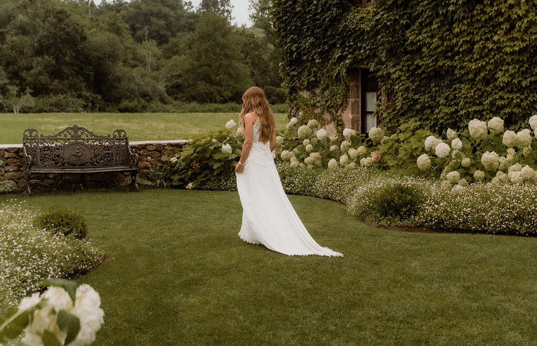 Novia de espaldas en los jardines de nuestra finca para bodas en Cantabria