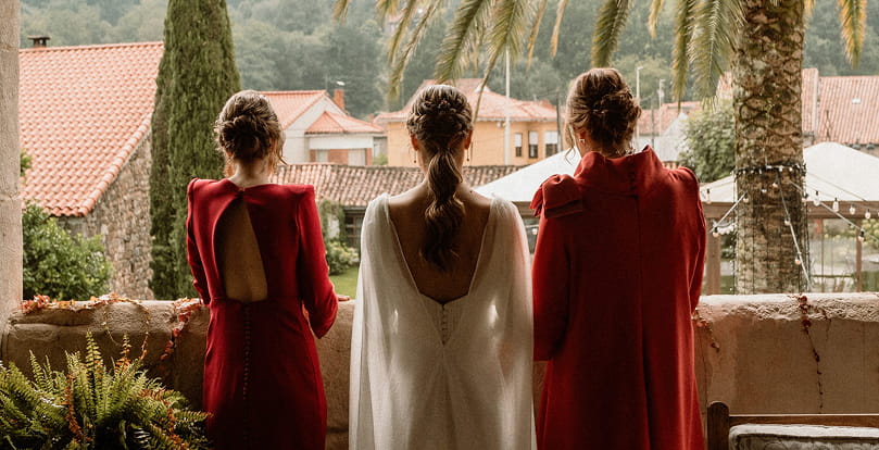 Novia de espaldas junto a dos damas de honor
