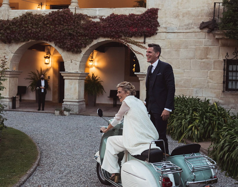 Pareja de novios llegando al palacio en una moto vintage con sidecar
