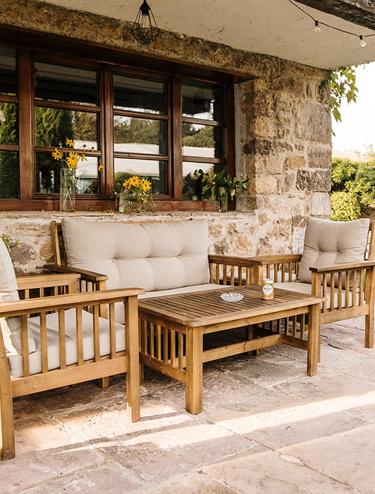Porche de nuestra casa rural, con mobiliario de exterior en madera