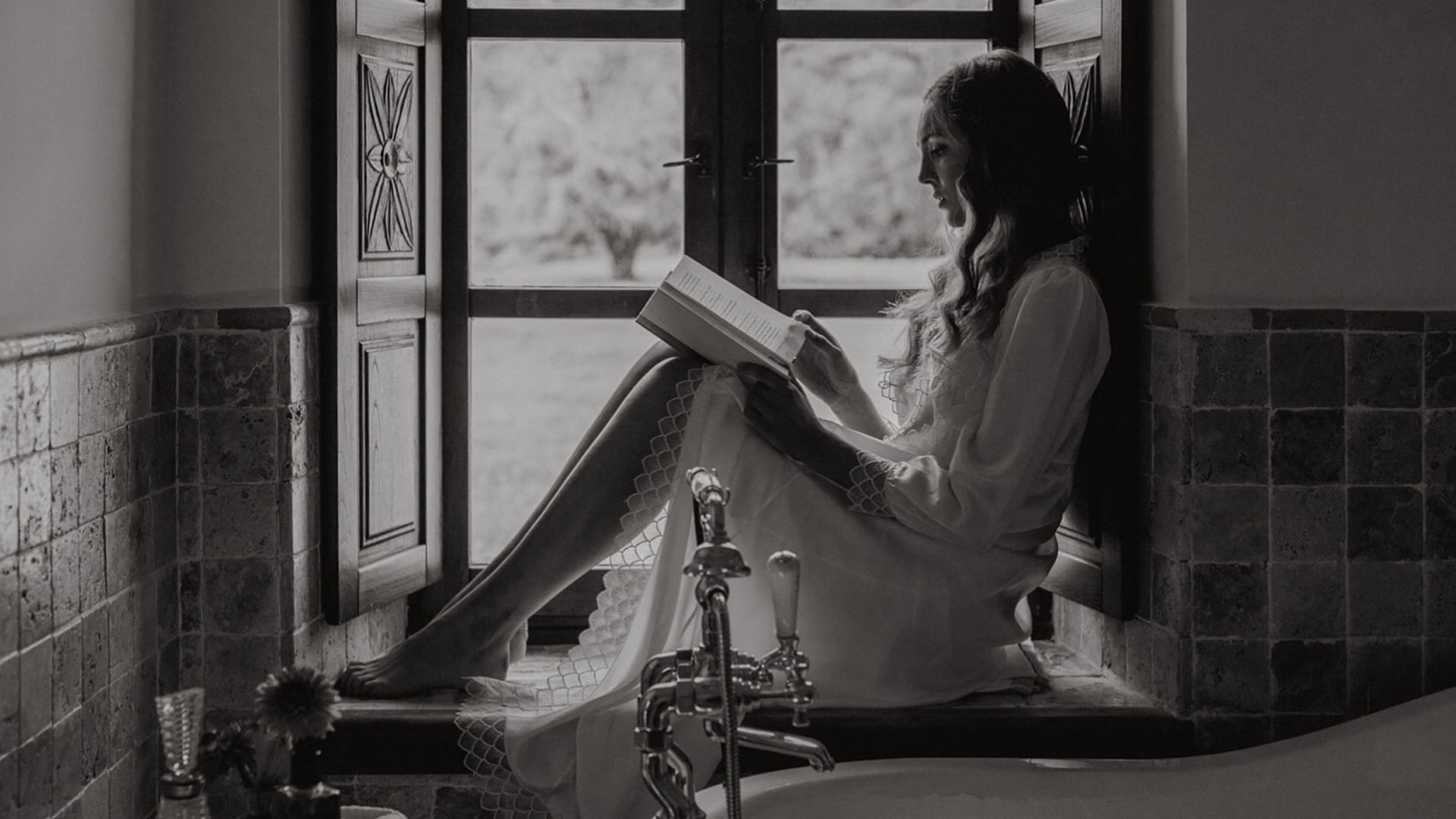 Novia leyendo un libro junto a la bañera de estilo victoriano