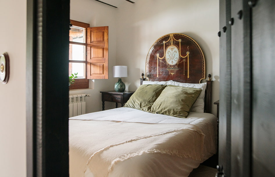 Una de las habitaciones de la Casa Rual, con cabecero original