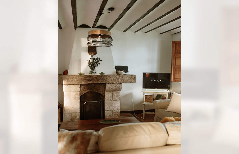Chimenea frente al sofá, junto a una pequeña TV