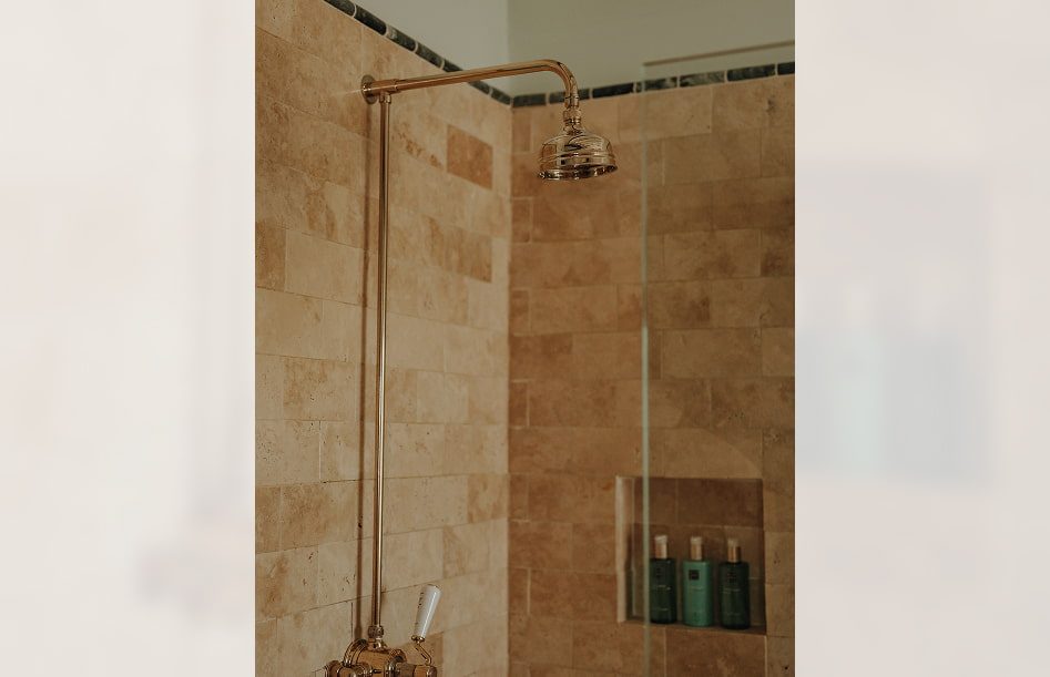Detalle de la zona de ducha, con grifería de estilo clásico