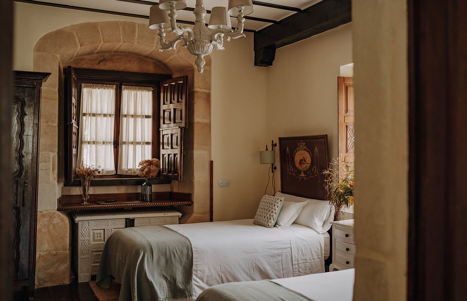 Habitación con dos camas individuales junto a una bonita ventana