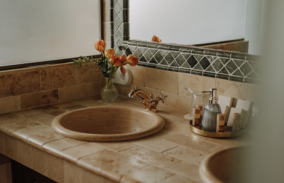 Detalle de la zona de lavabo, con flores y  productos de tocador