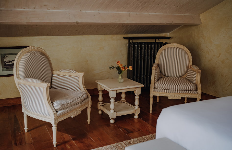 Butacas de estilo clásico, en uno de los rincones de la habitación