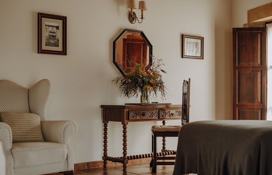 Mesa tipo escritorio con un jarrón con flores secas